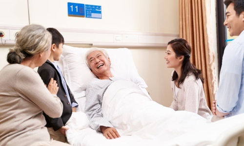 Asian family with child visiting grandparents in hospital